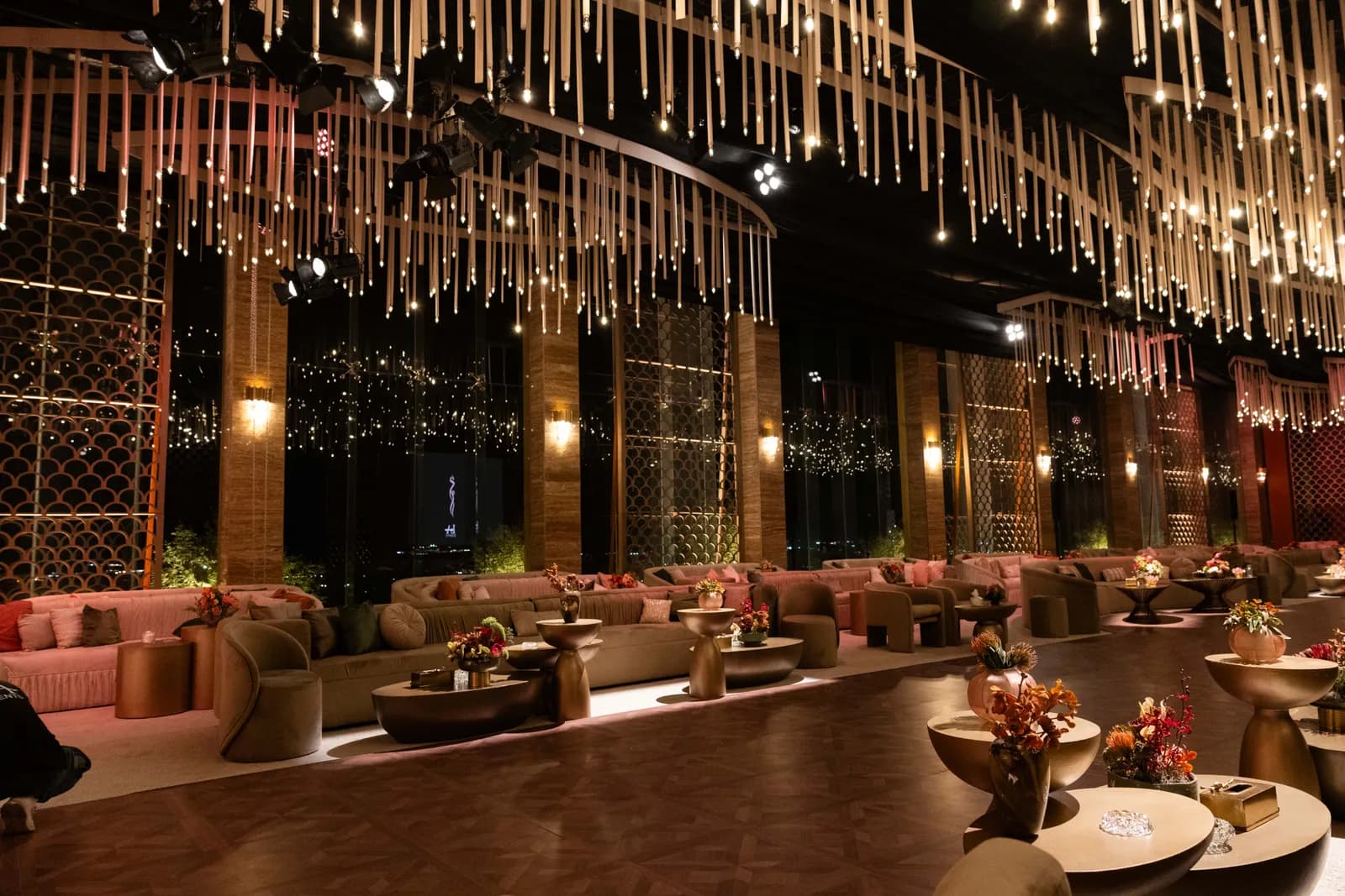 Long majlis dining table beneath a crystal fringe chandelier