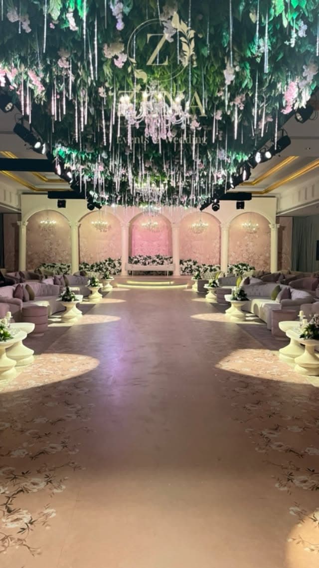 Blush floral arch wedding stage with soft romantic lighting